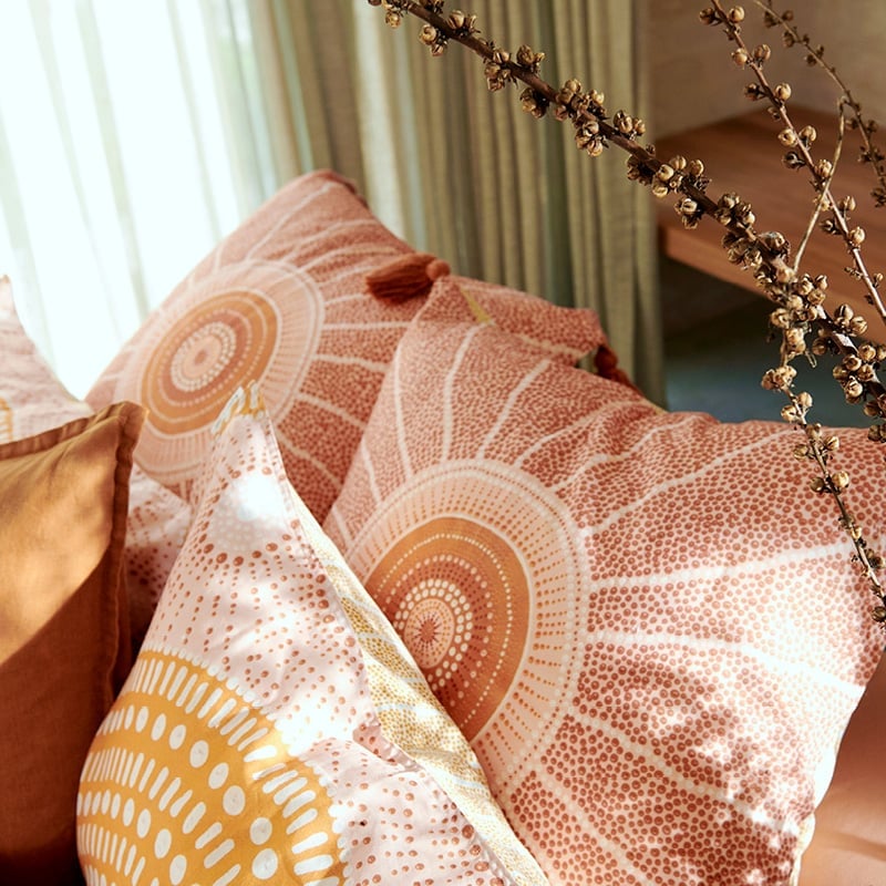 Overhead shot of the european pillowcases in the collection, dotted design in earthy tones against lighter shades of pastel pink and orange. 
