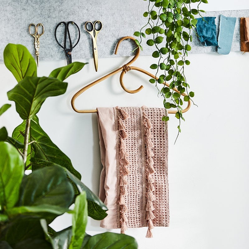 A coat hanger that’s pinned onto a mood board with a unique pattern sheet hanging off