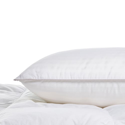 Microfibre (polyester) pillow sitting on top of a quilt. 