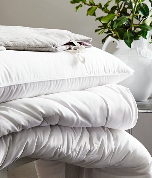 White minijumbuk pillow stacked on top of a matching mattress topper