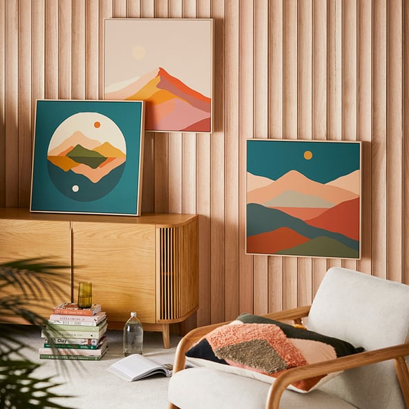 A living space with armchair and console, with Maus Haus art on the walls.