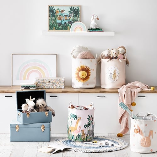 Toy room with storage bench styled with storage baskets, plush toys, kids accessories and wall art.