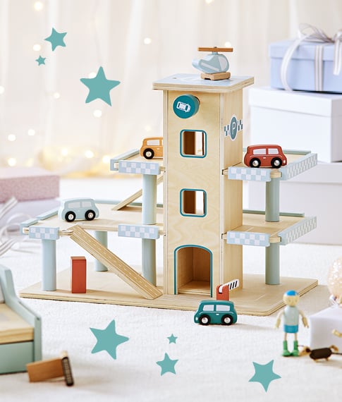 A natural wooden toy carpark with toy cars on each level painted in blue, orange and red with a helicopter on top.
