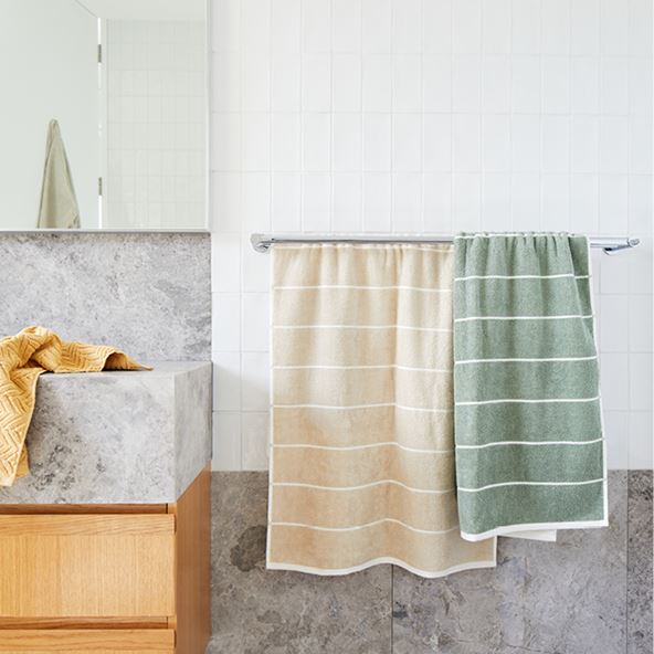 Bathroom setting with green and light brown towels placed on a towel rack