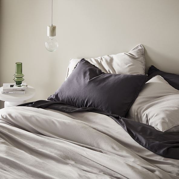 Close-up of bed styled with bamboo bedlinen in black and grey. 