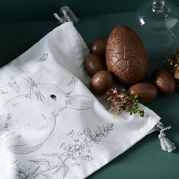Fleur Harris x Adairs Easter Egg Bag styled with a collection of chocolate Easter eggs. 