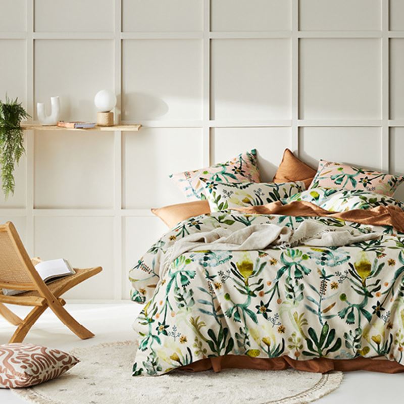 Botanical bedlinen with green flora and fauna in abstract watercolour on a neutral base, styled with natural accessories. 