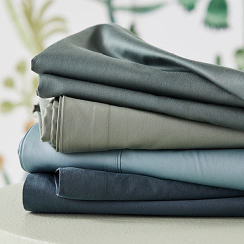 Selection of sheets in blue and green hues stacked on top of each other. 