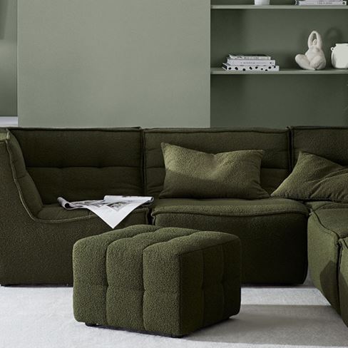 Boucle Otis Forest Lounge Chairs and matching Ottoman, styled in a living room with green wall. 