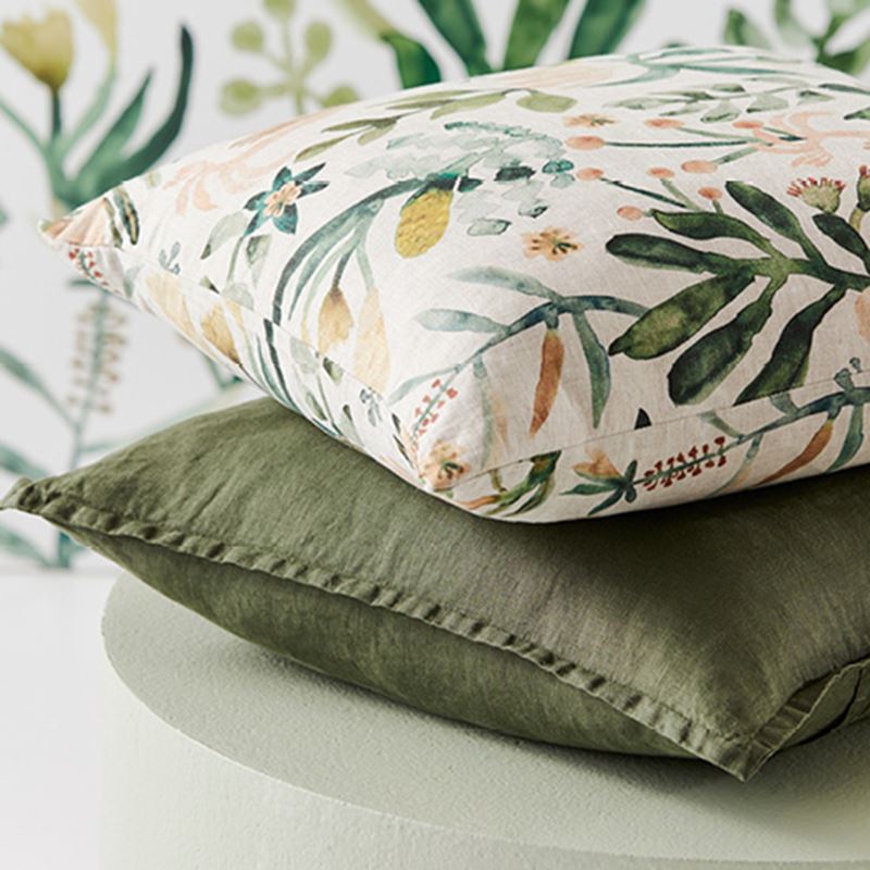 Two Belgian Vintage Washed Linen Cushions stacked - one dark green the other on top with a green floral pattern on neutral base.