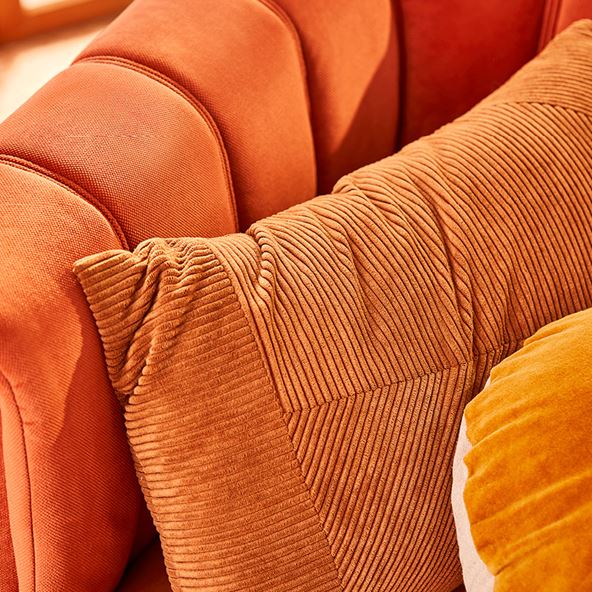 A close up image of orange cushions, on an orange armchair.