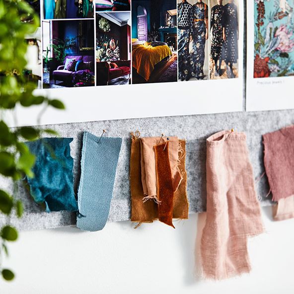 Collage of bed sheet materials and photos pinned against a board during a brainstorming session 