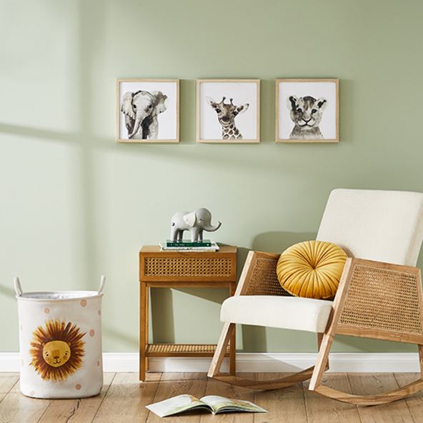 Arden Natural Rattan Rocking Chair, matching side-table and on the wall three animal prints. 